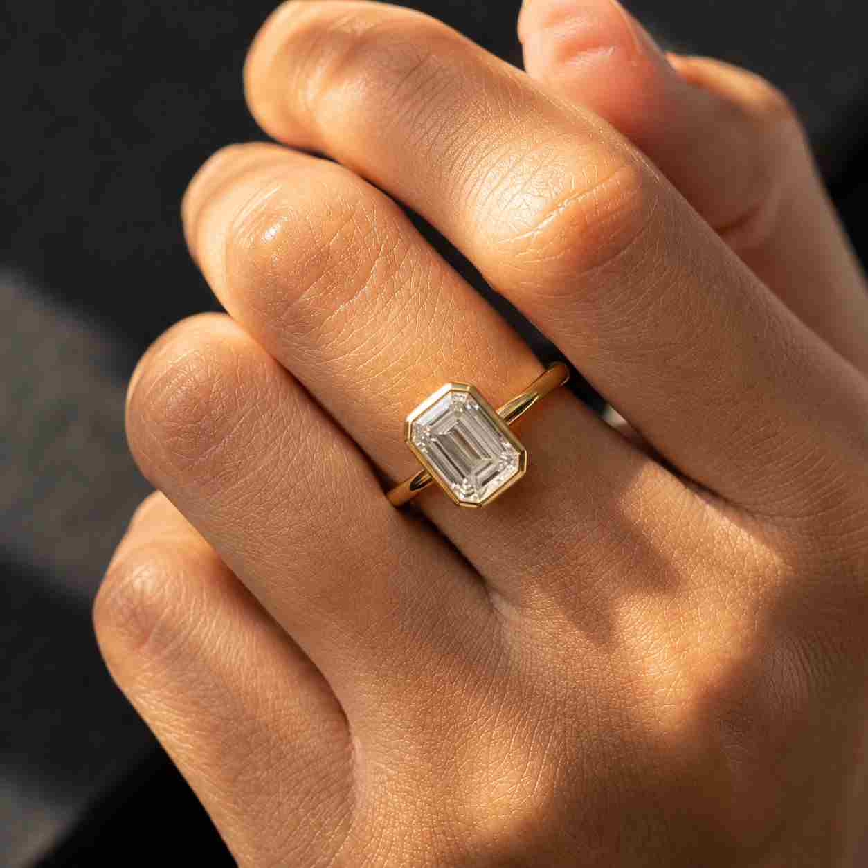Emerald cut diamond solitaire ring with 10K gold bezel setting