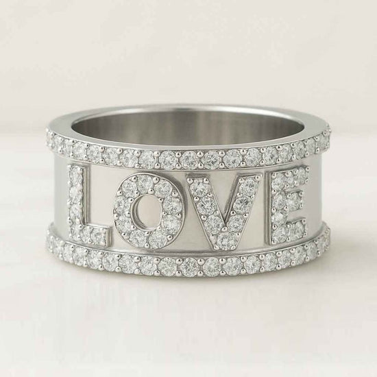 Silver ring with 'LOVE' letters and gemstones on a white background