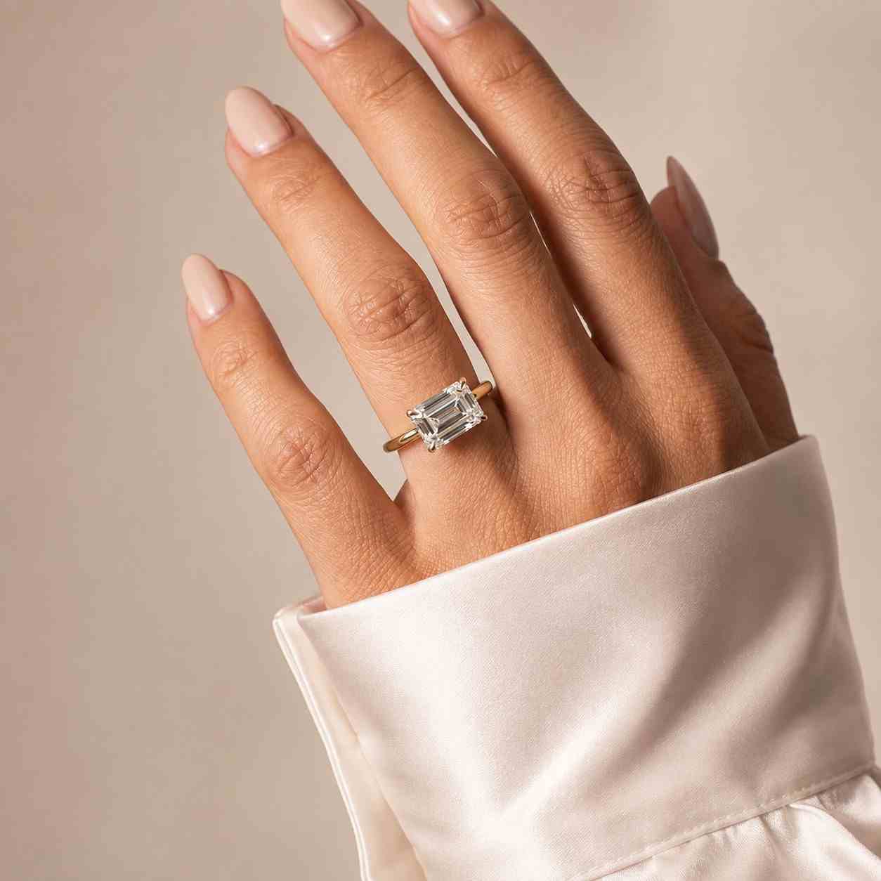 Large Emerald Cut Diamond Solitaire Engagement Ring Worn on Hand with Gold Band