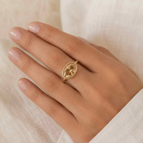 Oval champagne diamond bezel ring in yellow gold