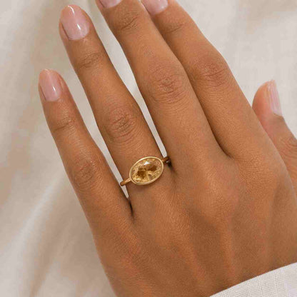 Oval cut brown diamond ring with yellow gold bezel setting
