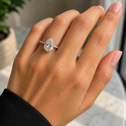 Pear cut moissanite diamond engagement ring with pave band