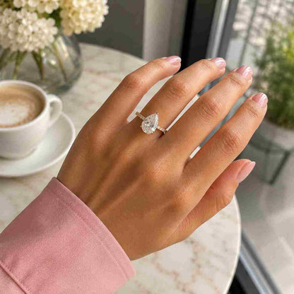 Pear shaped moissanite solitaire ring with diamond pave setting