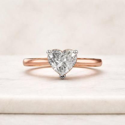 The heart-shaped center stone is secured with a classic three-prong setting that allows the diamond to remain the focal point while maintaining a light and balanced appearance.