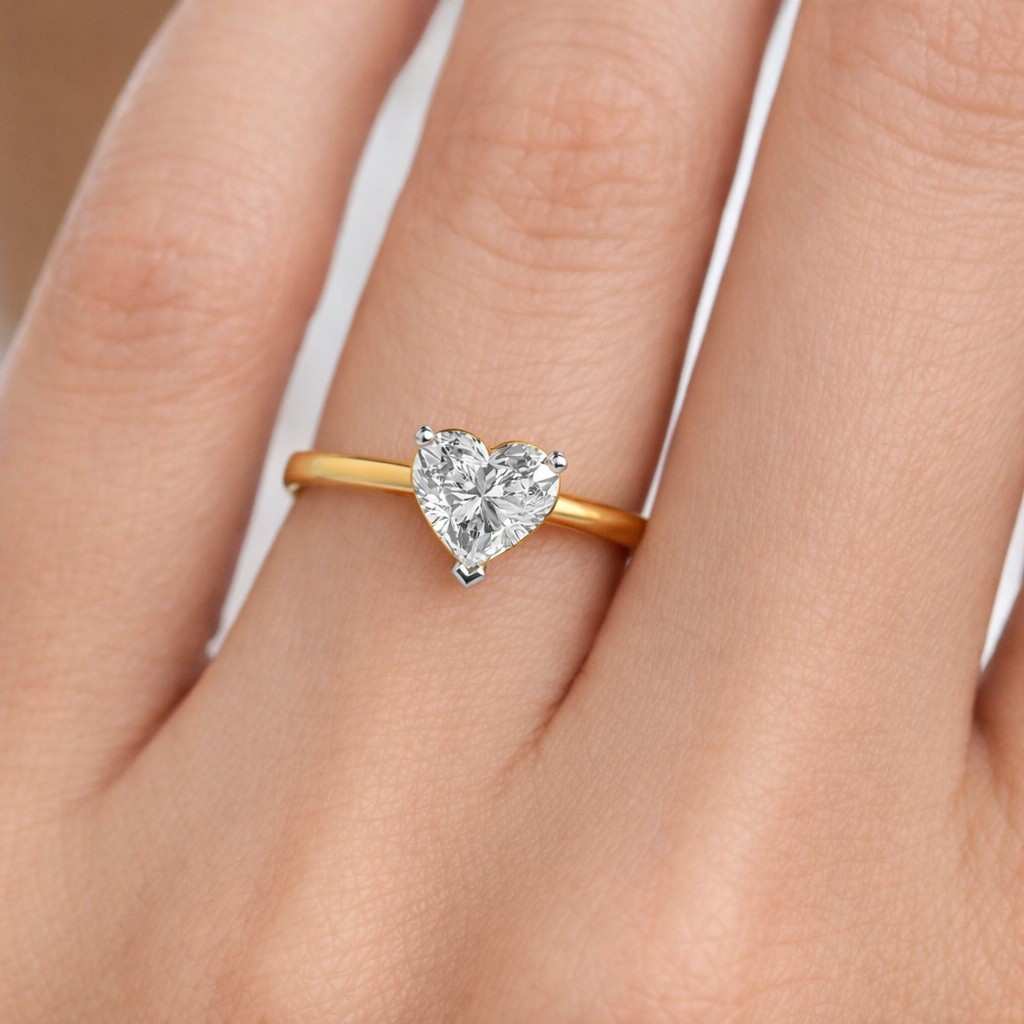 this heart cut lab grown diamond engagement ring features a clean solitaire design set on a polished yellow gold band.