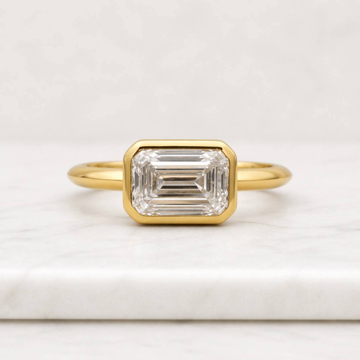 emerald cut ring bezel set ring gold ring solitaire ring statement ring geometric ring rectangle ring elegant ring womens ring fine jewelry luxury ring sleek ring polished ring modern ring classic ring