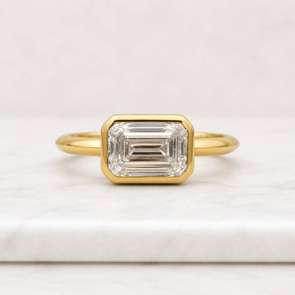 emerald cut ring bezel set ring gold ring solitaire ring statement ring geometric ring rectangle ring elegant ring womens ring fine jewelry luxury ring sleek ring polished ring modern ring classic ring