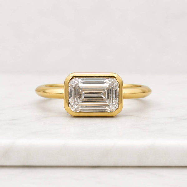 emerald cut ring bezel set ring gold ring solitaire ring statement ring geometric ring rectangle ring elegant ring womens ring fine jewelry luxury ring sleek ring polished ring modern ring classic ring