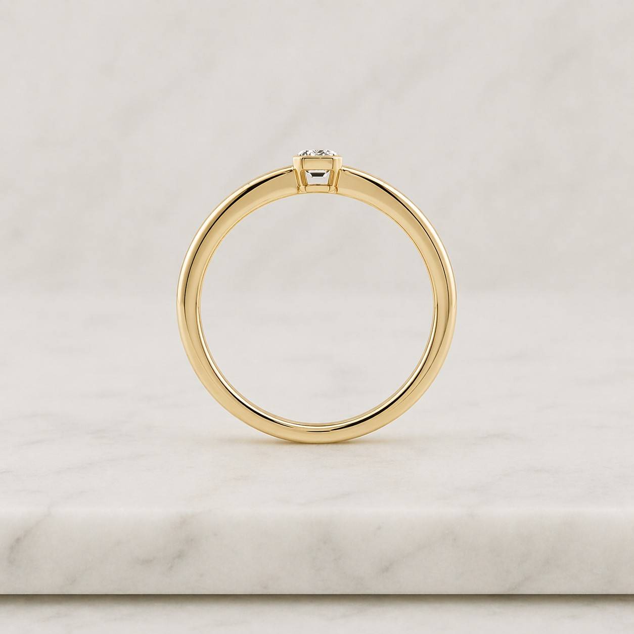 emerald cut lab grown diamond engagement ring, bezel set 14k yellow gold band

