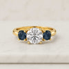 Round Cut Moissanite Three Stone Engagement Ring with Sapphire Side Stones
